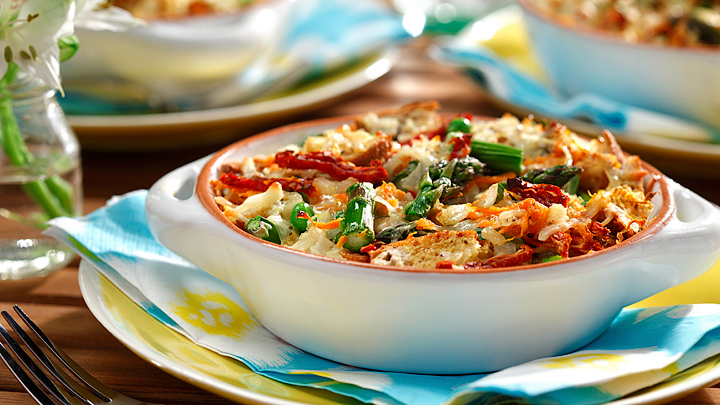 Breakfast strata primavera served in a white baking dish on top of a blue yellow and white napkin